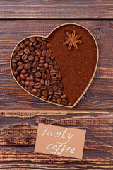 Heart-shaped coffee coffee beans and instant coffee. Tasty coffee concept. Brown wooden background.