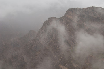 Cliff and isolated houses in the fog. The Nublo Rural Park. Tejeda. Gran Canaria. Canary Islands. Spain.