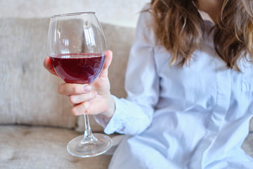 Girl drinks wine after work at home.