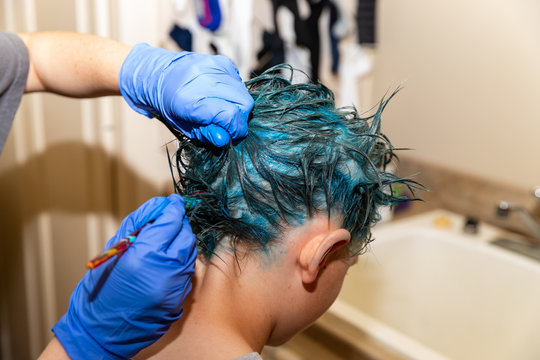 Young person having fun bright blue color dye applied to hair