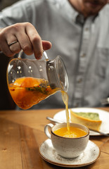 A man pours himself a tea drink.