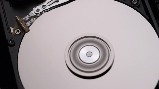 Macro, Close-Up of Computer Hard Disk Drive Spinning and Writing.  Slow Motion.