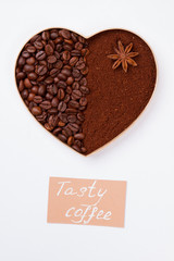 Decorative heart from coffee beans and powder with anise. Isolated on white background.