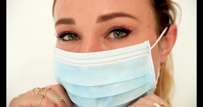Jeune femme mettant un masque pour se prot&eacute;ger des virus