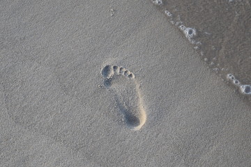 Śład małej stopy na plażowym  piasku