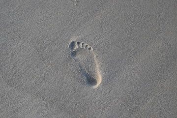 Śład małej stopy na plażowym  piasku