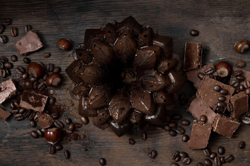pieces of chocolate on a dark wooden background. chocolate cupcake. spilled coffee beans