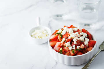 Fototapeta na wymiar Feta cheese tomato salad in a white bowl