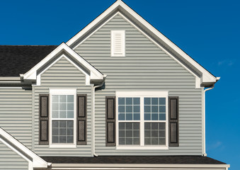 Classic American real estate single family home facade  with horizontal vinyl siding, double gable,...