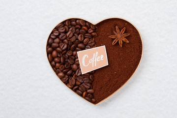 Decorative coffee heart made of beans and instant coffee. White isolated background.