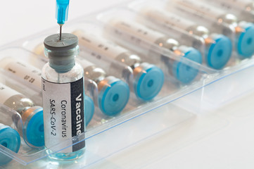 Medical syringe with glass ampoule vial with coronavirus COVID-19 vaccine. Fight of the coronavirus...