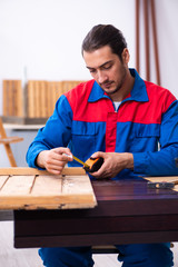 Young male contractor working in workshop