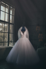 The bride's dress on the mannequin is waiting for the bride by the window