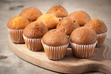 Small chocolate muffins on a wooden cutting board. Sweet dessert. Bakery products. Selective focus.