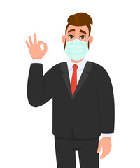 Young businessman wearing medical mask and showing okay, OK sign. Trendy hipster person covering face protection and gesturing hand symbol. Male character design cartoon illustration in vector style.