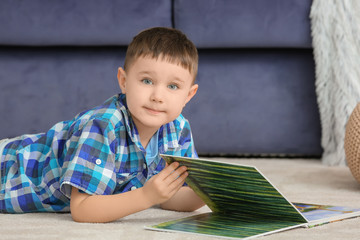 Cute little boy reading book at home