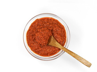Bowl with red pesto isolated on white background. Bowl of traditional Italian red pesto isolated on white from above.