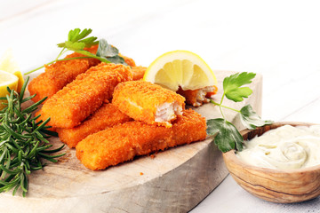 fresh fish fingers with remoulade sauce. breaded fish fingers with lemon and remoulade