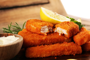 fresh fish fingers with remoulade sauce. breaded fish fingers with lemon and remoulade