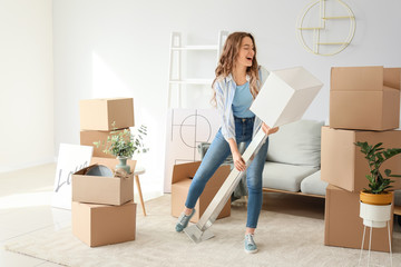 Happy young woman with belongings in her new home