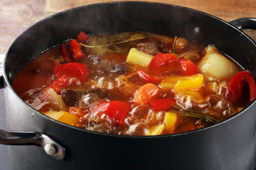 Meat stew with vegetables. Beef stew with potatoes, carrots and fresh herbs on table.