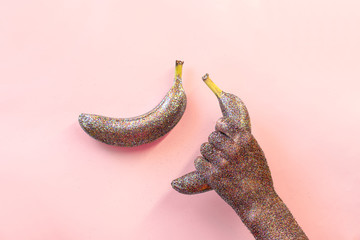 Hand with glitter holding a banana