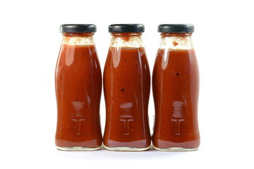 three Glass bottles of ketchup on white background