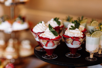 Colorful table with sweets and goodies for the wedding party reception, decoration dessert table. Delicious sweets on candy buffet. Dessert table for a party. cakes, cupcakes.