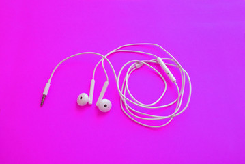 Headphones for a smartphone on a bright background, modern technology.