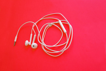 Headphones for a smartphone on a bright background, modern technology.