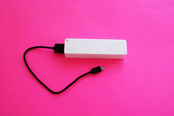 Obraz premium External battery with a USB port on a bright background, modern technology.