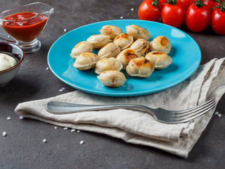 Russian pelmeni on the blue plate.