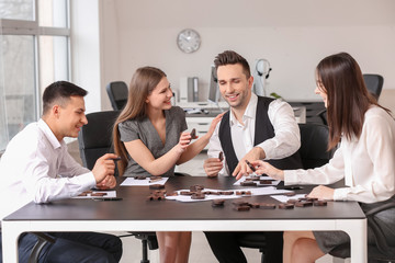 Team of business people composing words from letters in office
