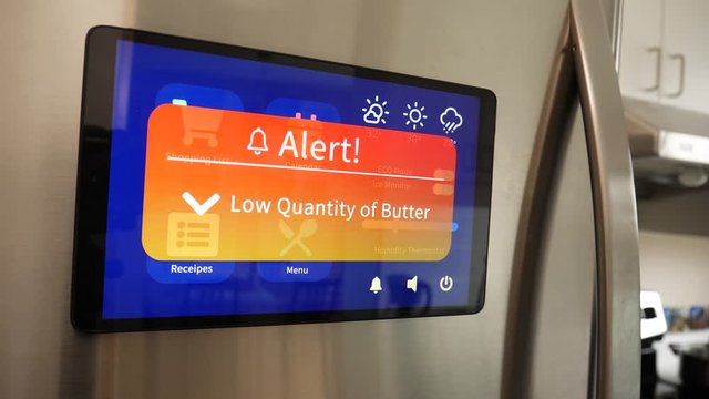 Smart Refrigerator announcing a warning alert on screen about low quantity of an ingredients inside , from the kitchen at home.