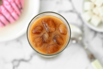 Glass of tasty iced coffee on table