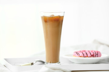 Glass of tasty iced coffee on table