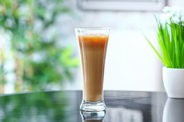 Glass of tasty iced coffee on table in cafe