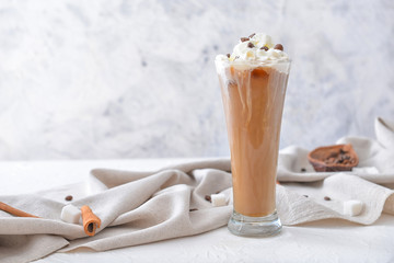 Glass of tasty iced coffee on table