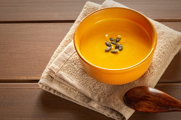 Roasted pumpkin and carrot soup with cream on a table. Copy space