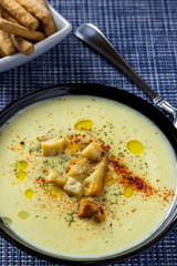 Zucchini cream without skin with olive oil, crunchy pieces of bread, parsley and paprika