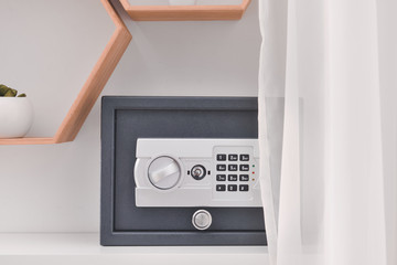 Modern safe on shelf in room