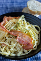 plate of spaghetti pasta or ribbons with cream egg and carbonara style bacon