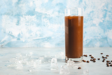 Glass of tasty cold coffee on color background
