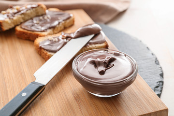 Fresh bread and chocolate paste on board, closeup