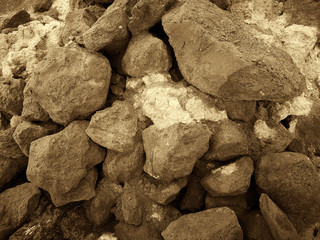 Titanium ore in pieces along with pieces of silicon. Mountain processing plant, the place of storage of the breed. Black and white image. Sepia. Horizontal frame.