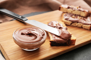 Fresh bread and chocolate paste on board, closeup