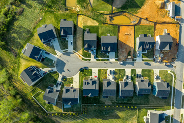 Aerial top down view of cul de sac dead end street with newly constructed single family homes and a...