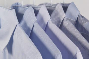 camisas colgadas en perchas planchadas en la tintorería