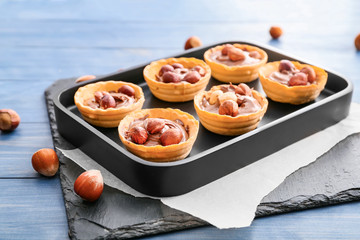 Tray with tartlets and tasty chocolate paste on table
