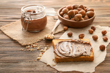Fresh bread and chocolate paste with hazelnuts on table